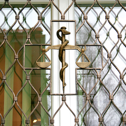 Forged scales as a symbol of medicine on window grilles – detail Forged scales as a symbol of medicine on window grilles – detail
